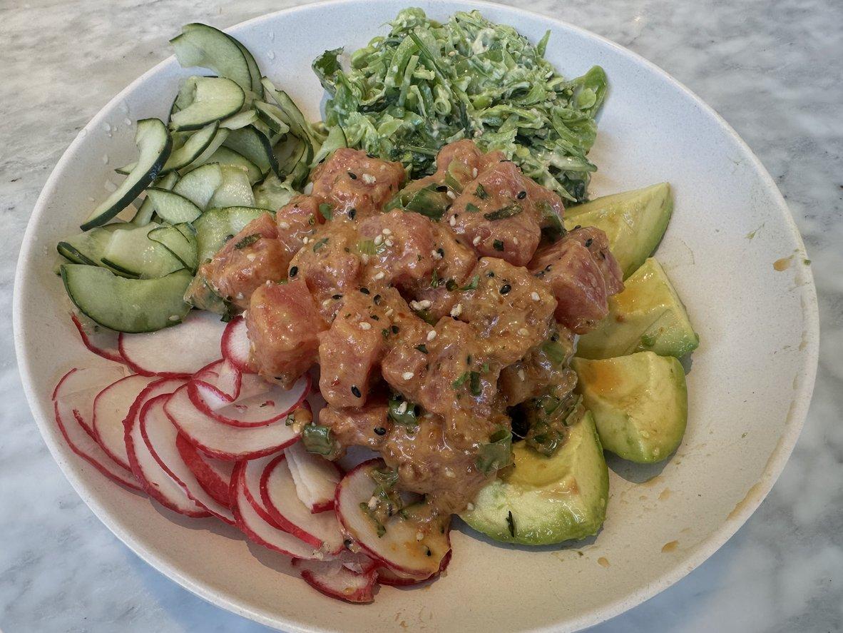 Ahi tuna rice bowl with avocado, cucumber, greens, and creamy sesame dressing