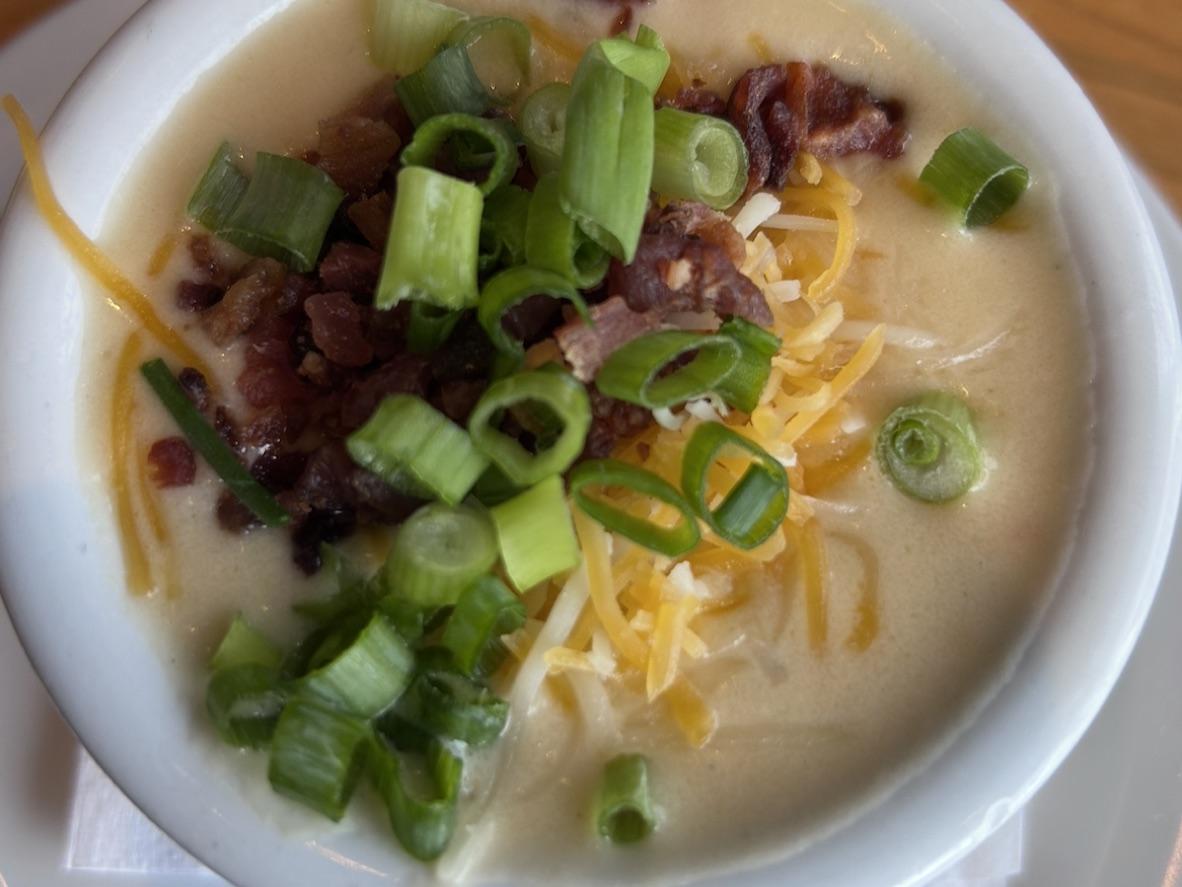 Creamy loaded baked potato soup topped with bacon, cheddar, and sliced green onions
