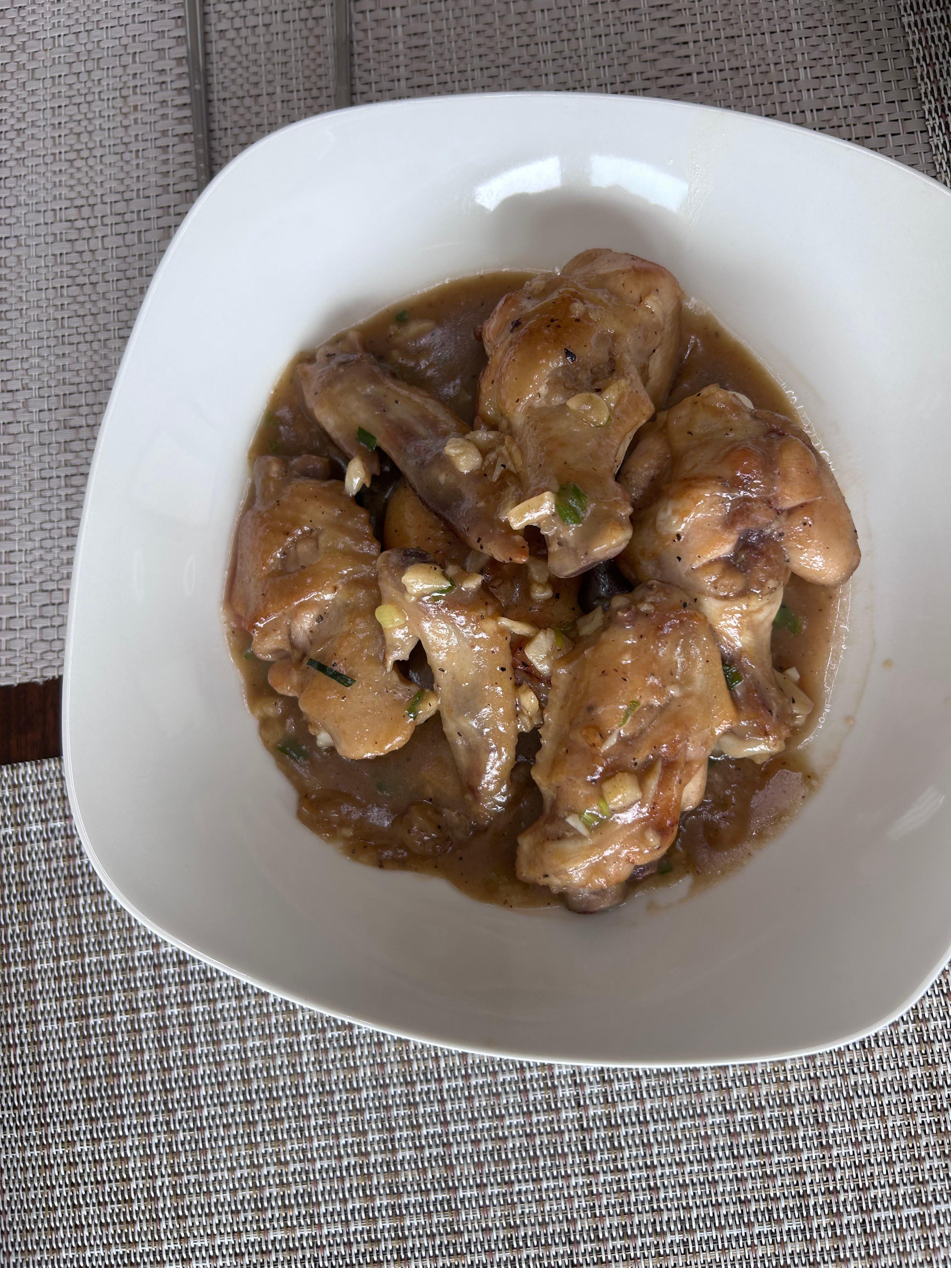 Home-cooked chicken wings with a glossy garlic sauce on a serving plate